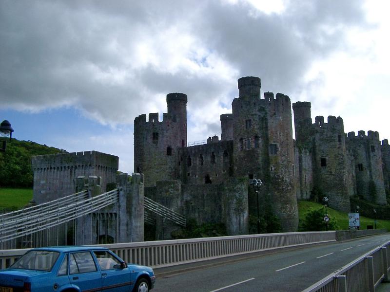 Blue Car Passing the Bridge Near the Historic Conway Castle, Located in Wales.