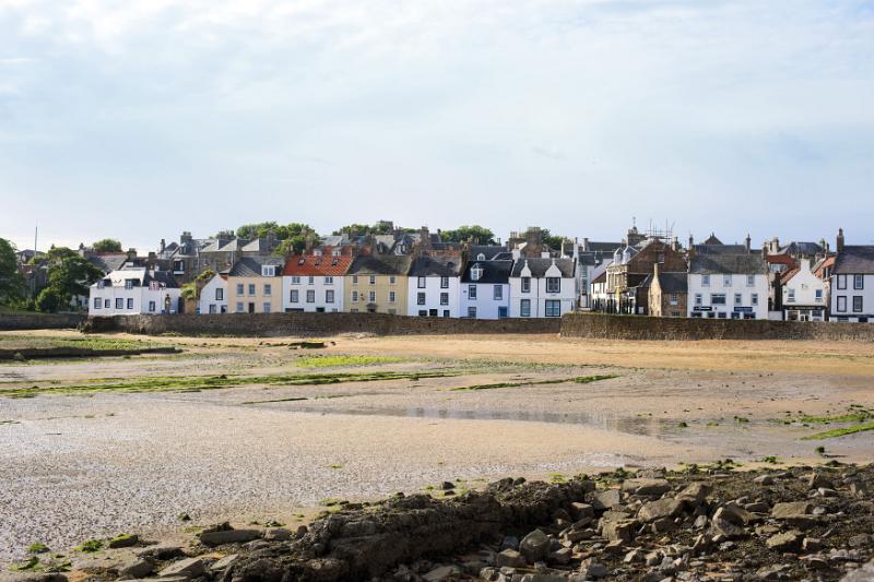 Landscape view of the coastal town of Anstruther, Fife, Scotland looking across the beach to waterfront houses at low tide
