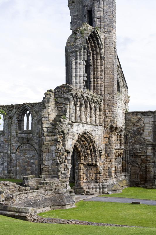 Graceful Gothic stone arches and remnants of wall in St Andrews Cathedral ruins, Scotland against a grey sky with copy space