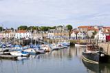 Picturesque view of a tranquil Anstruther harbour on the Fife coast in Scotland with moored yachts, pleasure and fishing boats