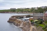 Scenic small boat harbour, Crail, Scotland on the Fife coast with steps leading to a seawall enclosing a sheltered fishing harbor with moored boats