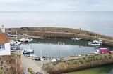 High angle view of serene scottish marina enclosed by a stone wall separating it from the ocean