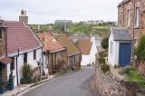 Little traditional houses built close together on downward empty road in Crail, Scotland