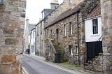 Narrow street lined with stone walled houses in little village at Saint Andrews, Scottland