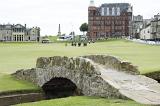 Swilken Bridge, St Andrews golf course, Scotland with a view of the town behind and a group of people on the fairway