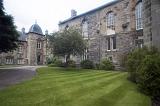 Grounds and historic buildings of St Andrews University, Scotland showing manicured lawns and old stone architecture with graceful arched windows
