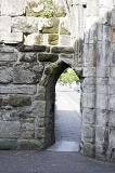 Old weathered and mossy stone arch doorway in ruins of church in St Andrews, Scotland
