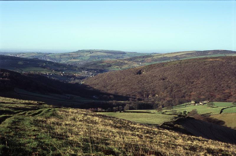 View across the Kinder Scout moor land with its rolling hills, grassland and pasture on a sunny clear blue sky day, Derbyshire, UK