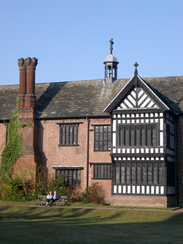 Visitors Sitting on the Bench in Front of the Bramhall Hall, a Tudor manor house in Bramhall, within the Metropolitan Borough of Stockport, Greater Manchester, England.
