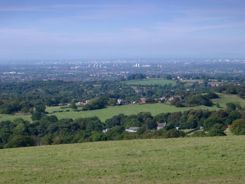 Lush English countryside looking towards the city of Manchester in the distance with the view encompassing the whole city