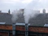 Two factory smoke stacks spewing steam into the air in industrial Manchester at the MOSI museum, Lancashire, England