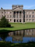 Imposing exterior facade of Lyme Park, a mansion house surrounded by formal gardens, in a deer park in the Peak District National Park