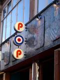Signage for the Pop Cafe, a 1960s retro vegetarian eatery, on the front of a building amongst decorative tiles