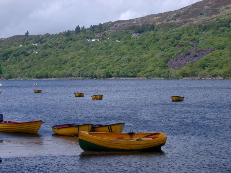 Wooden rowboats moored on the lake at Llanberis, Gwynedd, North Wales on a cloudy day