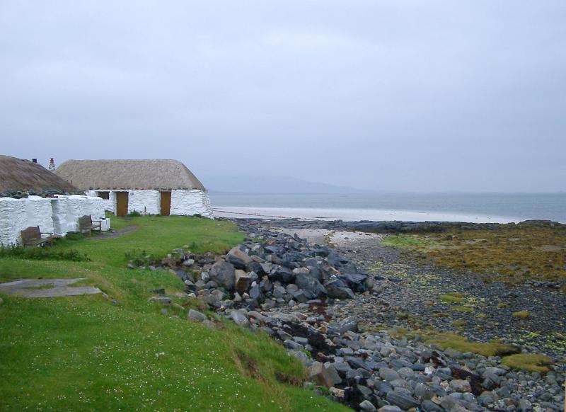 traditional whitewashed thatched youth Hostel on the Isle of Barra in the Outer Hebrides, Scotland overlooking the ocean