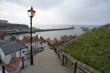a view down whitbys famous 199 steps towards the harbour seawalls and town