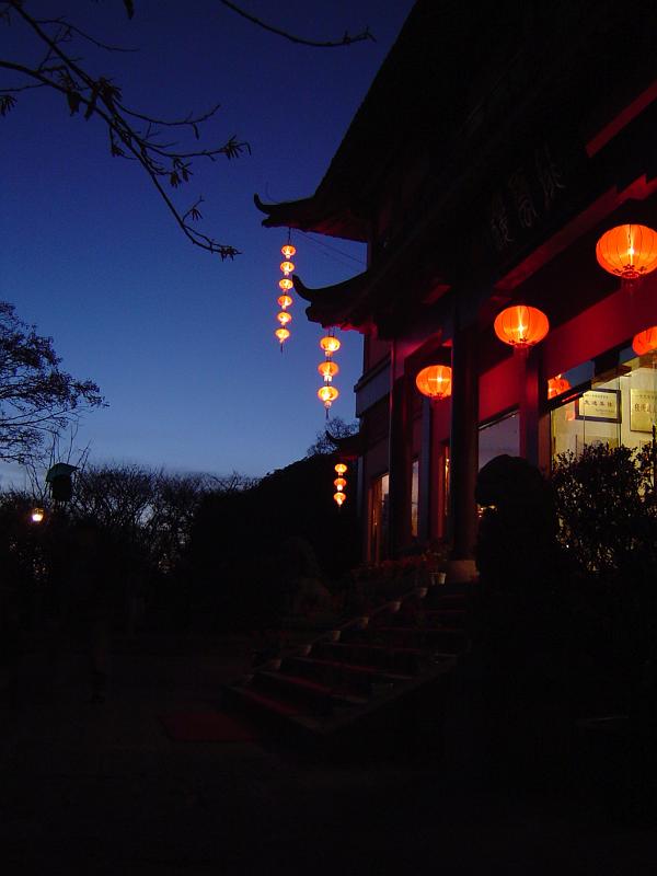 Night scene of a traditional Chinese house with colorful lighted lanterns hung at the entrance as a welcome to visitors