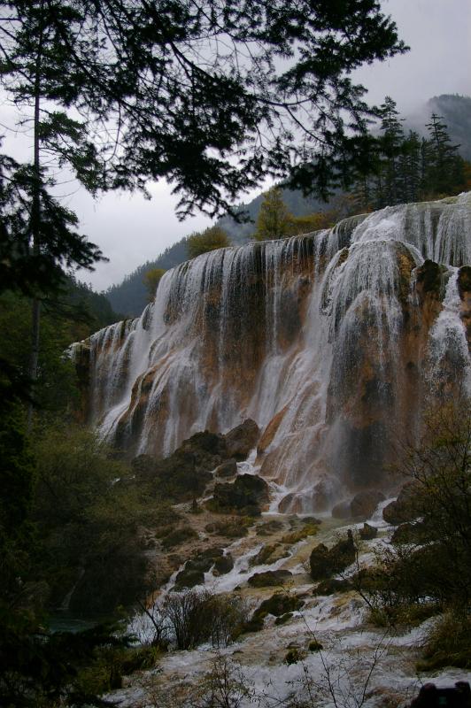 Beautiful Attraction of Natural Chinese Waterfalls Surrounded by Green Plants and Trees.