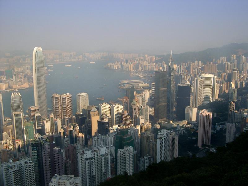 Hong Kong cityscape on a hazy day showing the densely packed modern architecture and skyscrapers with a view out to sea