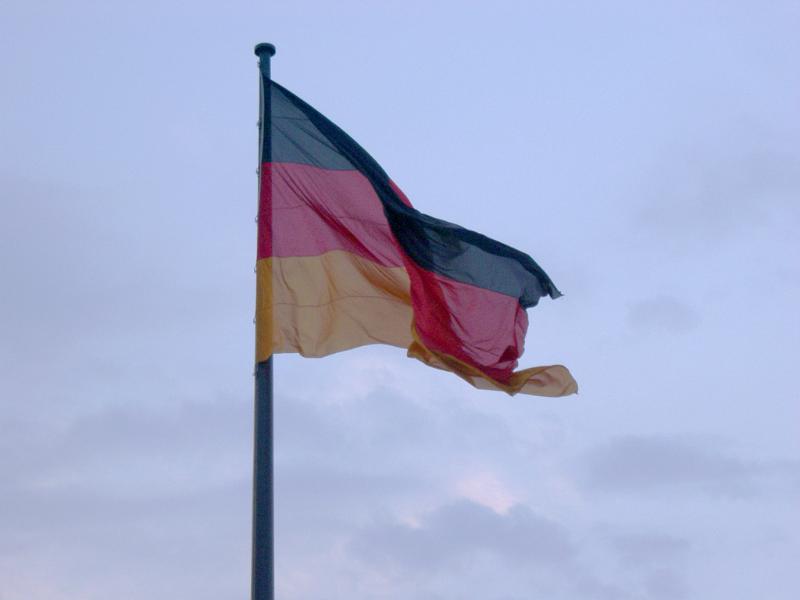 Flag of Germany fluttering in the wind against a cloudy sky, symbol of German national pride and identity