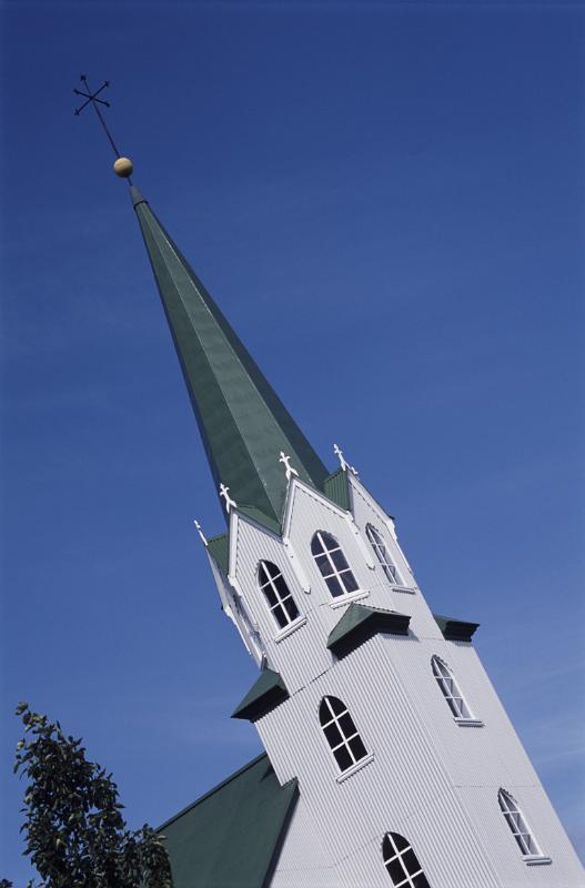 Elegant church spire in Reykjavik , Iceland, with traditional architecture of a corrugated iron roof against a blue sky