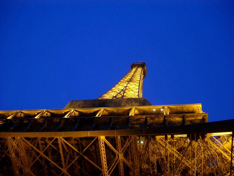 Looking Up at Eiffel Tower with Lights On Against Blue Night Sky, Paris, France