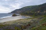 Beautiful Big Sur Coast Seascape in Extensive View. Captured with Relaxing Sea, Grassy Campground and Huge Mountain. Isolated on Light Gray Sky Background.