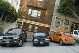 Cars parked side by side in front of residential houses on a steep hill in San Francisco, California, USA