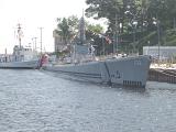 Historical US navy submarine moored on the surface at a dock under colorful bunting