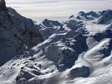 Ice Snow Covering Mountains in France on Light Gray Sky Background. Captured in Aerial Extensive View.