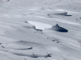 Wind Blown Sand-like Ice Snow on the Field During Winter Season.