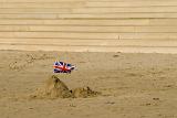 a simple sand castle with a union jack stuck in it