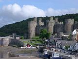 view of historic conwy castle and fishing boats at a jetty on the banks of the conwy river