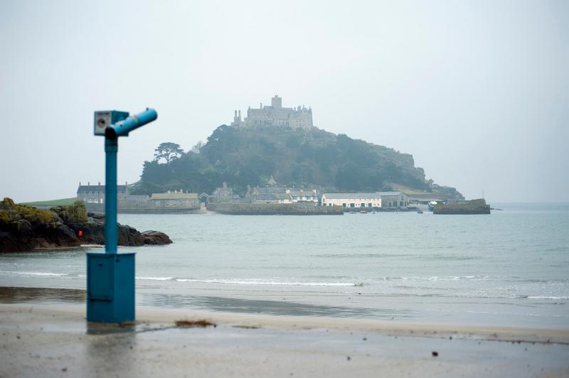 a rainy day view looking out to sea towards st michaels mount and monastery