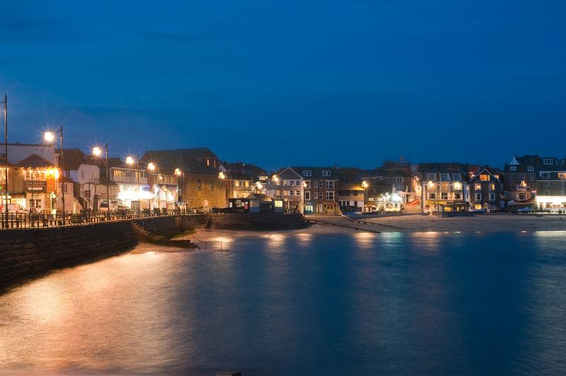 shops and bars brightly lit on the waterfront of saint ives, cornwall