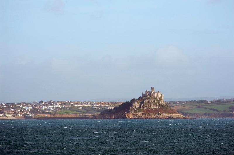 a view of the back of saint michaels mount taken from across the water and town of marazion