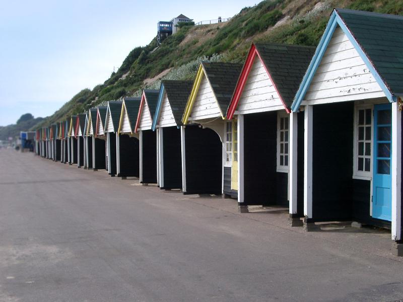 colorful line of beach huts on bournemouths promenade seafont