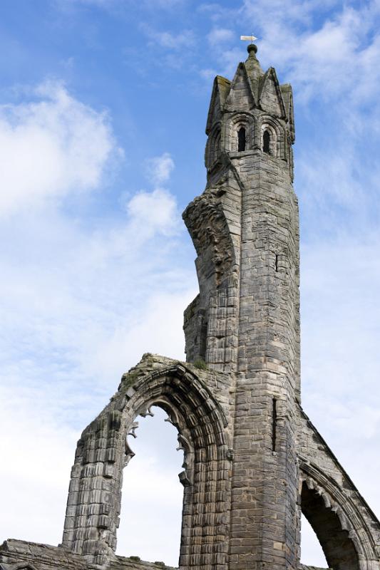 Old stone carved tower of Saint Andrews Cathedral Low angle view on old stone carved tower of Saint Andrews Cathedral under partly sunny sky