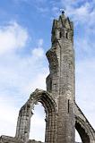 Low angle view on old stone carved tower of Saint Andrews Cathedral under partly sunny sky