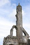 tall ruin tower of St Andrews Cathedral, Scotland with the remnants of an old Gothic window alongside a spire against a cloudy blue sky
