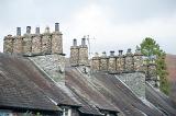 Roofs and traditional cylindrical chimney pots constructed of stone on Cumbrian cottages in the Lake District