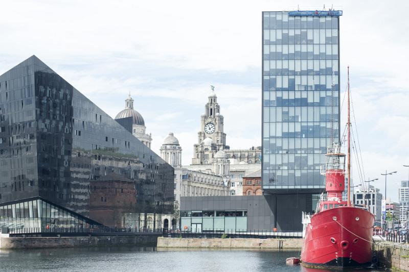 Large red Lightship moored at dock near modern glass buildings in Liverpool, United Kingdom