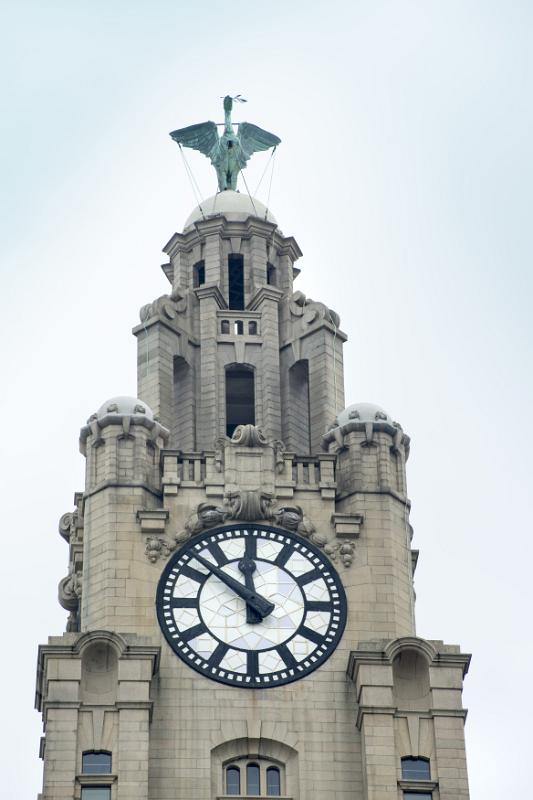 Close up on Liver Building clock tower with statue on top in Liverpool, United Kingdom