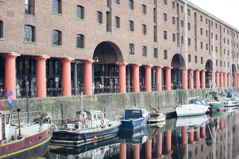Various little boats docked at the Albert Dock Large red support columns reflecting in water with various little boats docked at Liverpool Albert