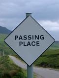 Passing Place roadsign in Scotland on a single lane rural road indicating a safe place for vehicles traveling through the Highlands to pass