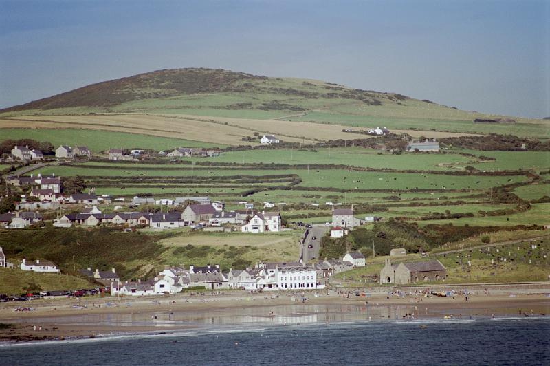 Picturesque view of Aberdaron on the Welsh coast of the Llyn peninsula set amongst lush green rolling hills