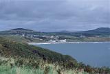 Picturesque village of Aberdaron on the Llyn peninsula in Wales with whitewashed buildings nestled around a sandy beach amidst rolling green hills