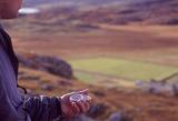 Man holding a compass in his hand when out walking in the mountains of Scotland to navigate using magnetic north