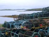 Wire mesh crab pots stacked on the seashore of a loch in Scotland