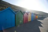 a line of beach huts on the shore at whitbys west cliff